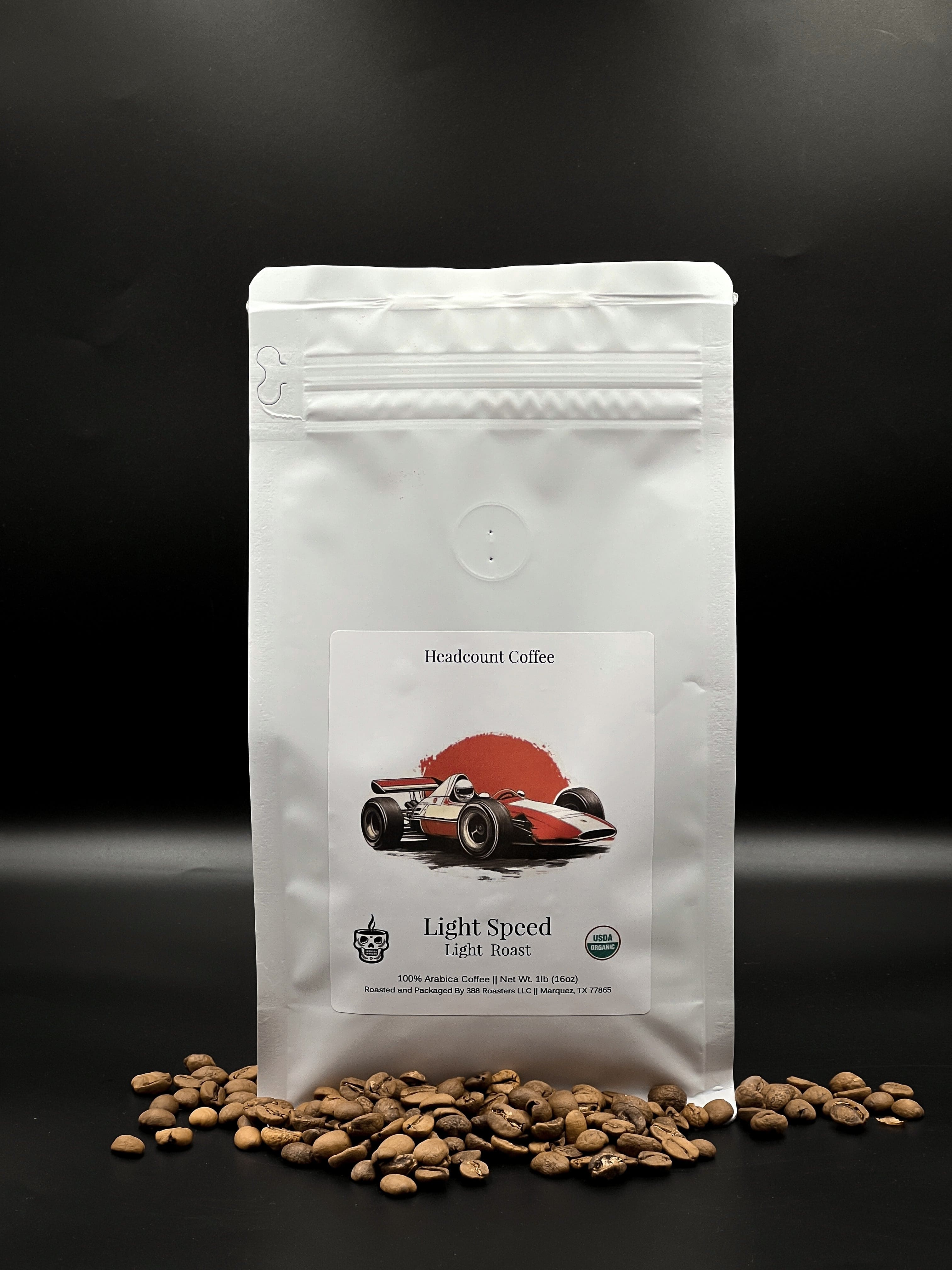 A sealed pouch packaging of Headcount Coffee's Light Speed Coffee with a graphic of a red racing car on the front, accompanied by coffee beans scattered in front of the pouch on a dark background.