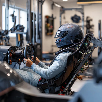 Formula 1 driver training indoors during winter break with neck harness, molded seat and gym equipment
