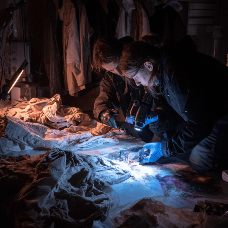 Forensic investigator scanning Dyatlov hikers’ clothing with a Geiger counter, showing isolated radiation patches.