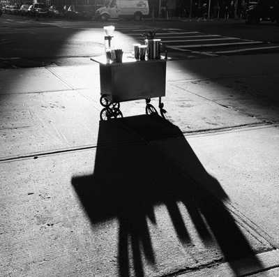 A Blue Bottle style cold brew cart sitting unused on a city sidewalk, representing the collapse of the brand’s mobile vending experiment.