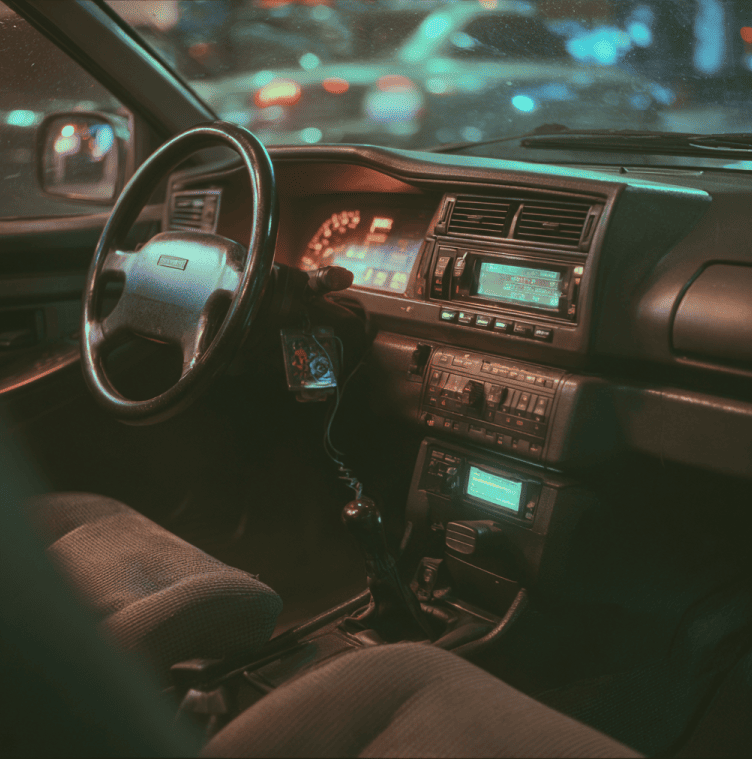 OBD-II diagnostic port under a car dashboard illustrating the introduction of standardized vehicle self-diagnostics.