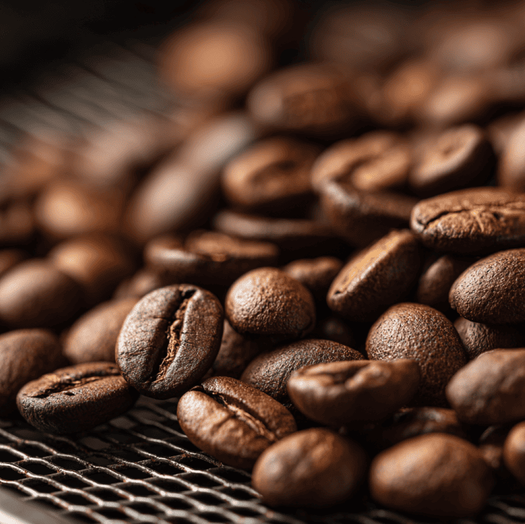 Freshly roasted coffee beans resting and degassing in a cooling tray to develop flavor over 72 hours.