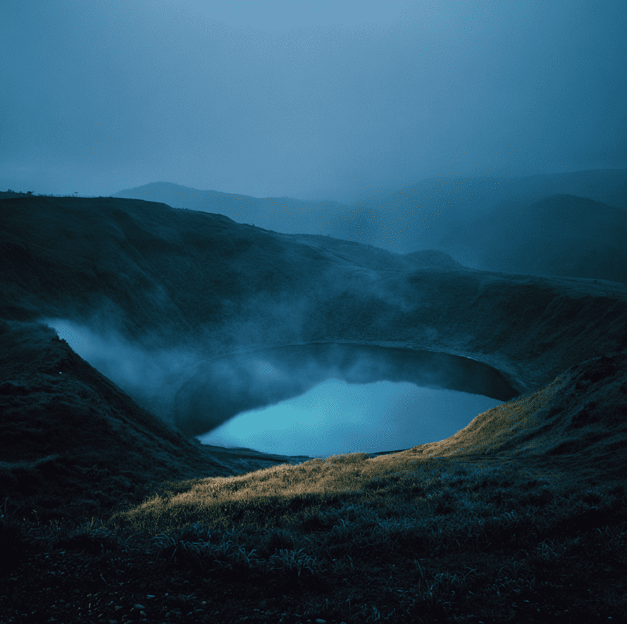 Calm crater lake with low-lying mist representing the CO₂ cloud from the 1986 Lake Nyos disaster in Cameroon.