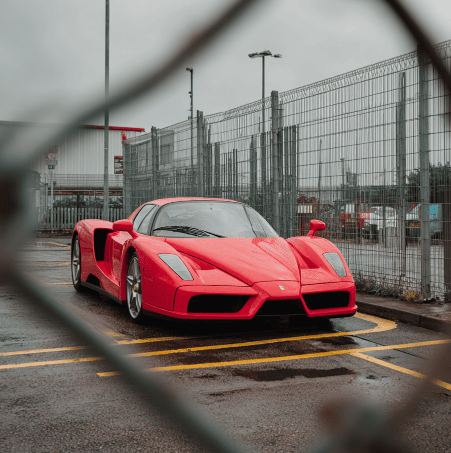 Impounded Ferrari Enzo behind a fence in London, representing the mysterious unregistered hypercar discovered in 2011.