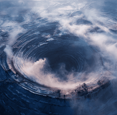 Aerial photo of the massive Mirny Diamond Mine pit, showing the depth and shape linked to dangerous downdrafts and whirlwinds.
