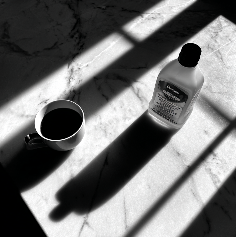 spilled coffee cup on kitchen counter beside bleach bottle, symbolizing domestic argument and tragedy