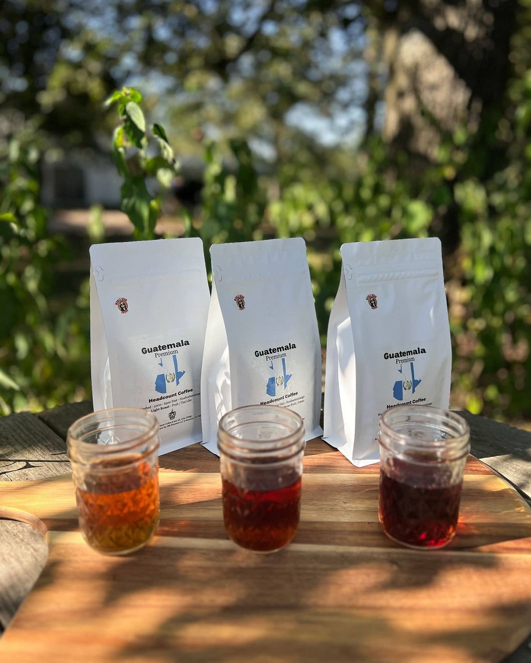 Headcount Coffee Guatemala Flight with light, medium, and dark roasts on display outdoors.